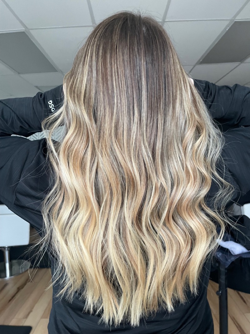 Lived-in balayage by Cait Bongiorno: long blonde waves blended from a soft, natural root